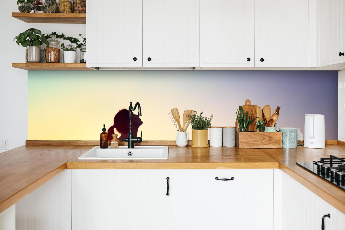 Küche - Glückliche Frau beim Sonnenuntergang in weißer Küche hinter Gewürzen und Kochlöffeln aus Holz
