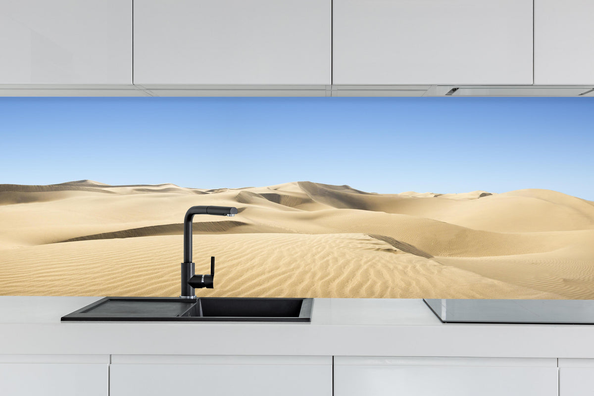 Küche - Gold desert hinter weißen Hochglanz-Küchenregalen und schwarzem Wasserhahn