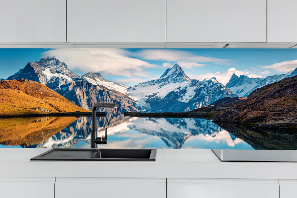 Küche - Panoramablick auf Bachalpsee hinter weißen Hochglanz-Küchenregalen und schwarzem Wasserhahn