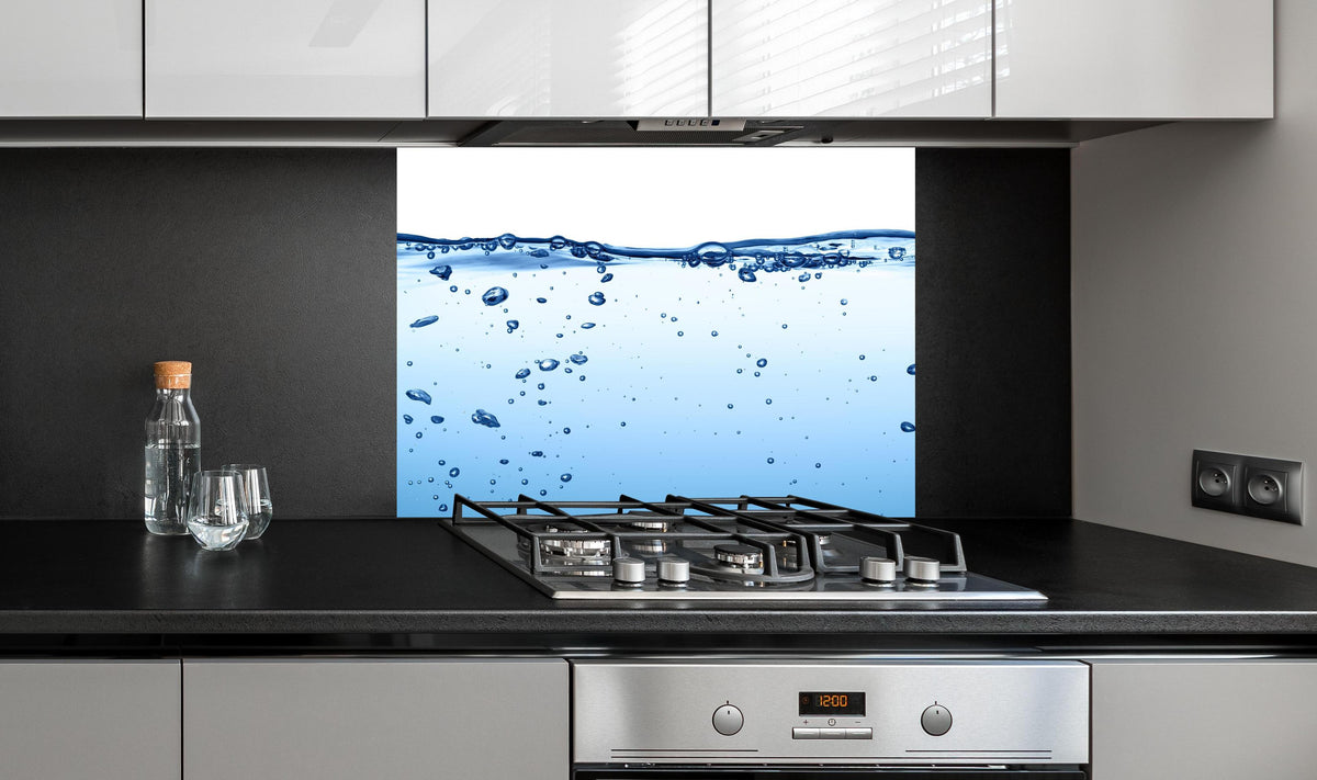 Spritzschutz - Energie des Wassers an edler Anthrazit-Wand hinter silbernem Gasherd