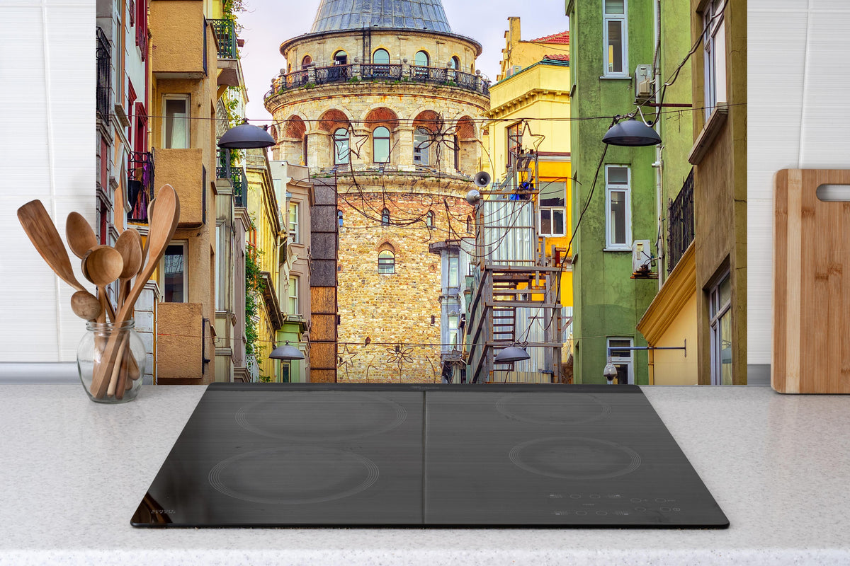 Spritzschutz - Galata-Turm in der Altstadt von Istanbul hinter einem Cerankochfeld zwischen Holz-Kochutensilien
