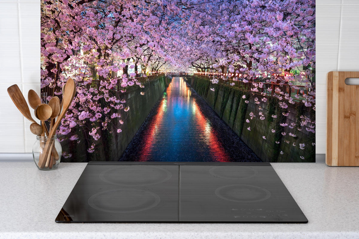 Spritzschutz - Kirschblüten bei Nacht Nakameguro - Tokio hinter einem Cerankochfeld zwischen Holz-Kochutensilien