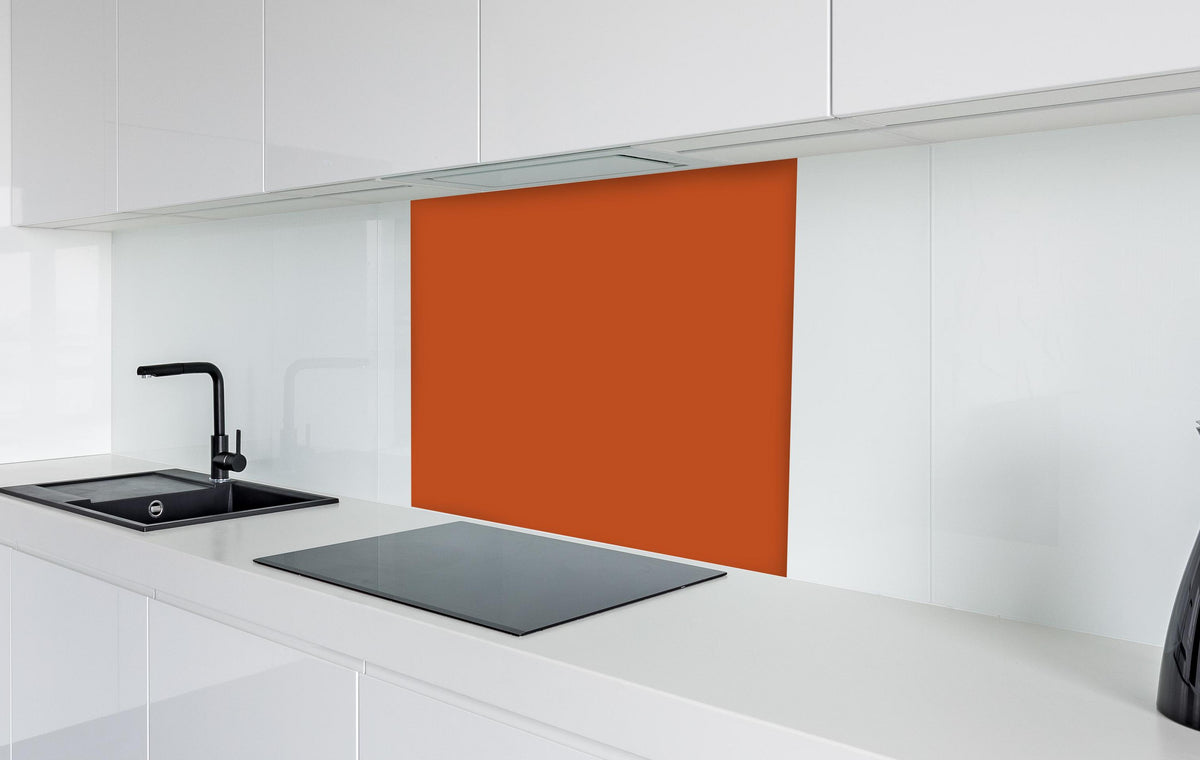 Spritzschutz - RAL 2001 (Rot-Orange) in weißer Hochglanz-Küche hinter einem Cerankochfeld