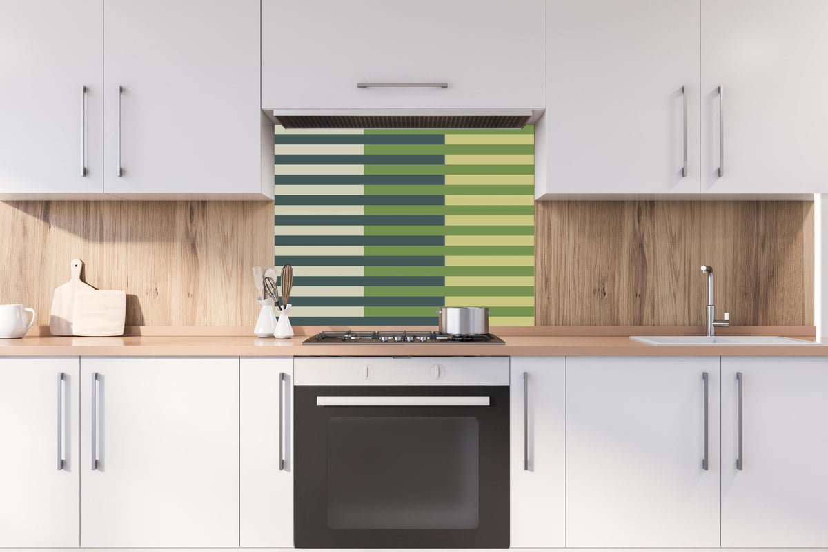 Spritzschutz - The Greens - Multy Stripes - Pistachio hinter einem Cerankochfeld zwischen Holz-Kochutensilien