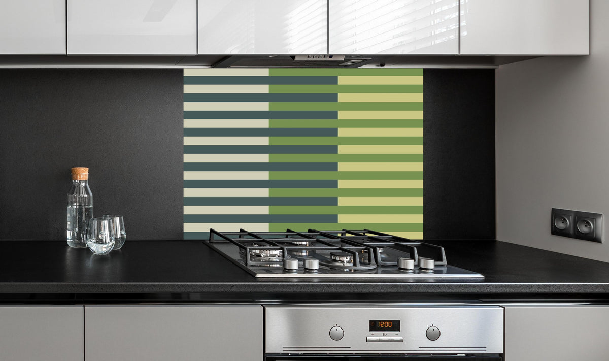 Spritzschutz - The Greens - Multy Stripes - Pistachio hinter einem Cerankochfeld zwischen Holz-Kochutensilien