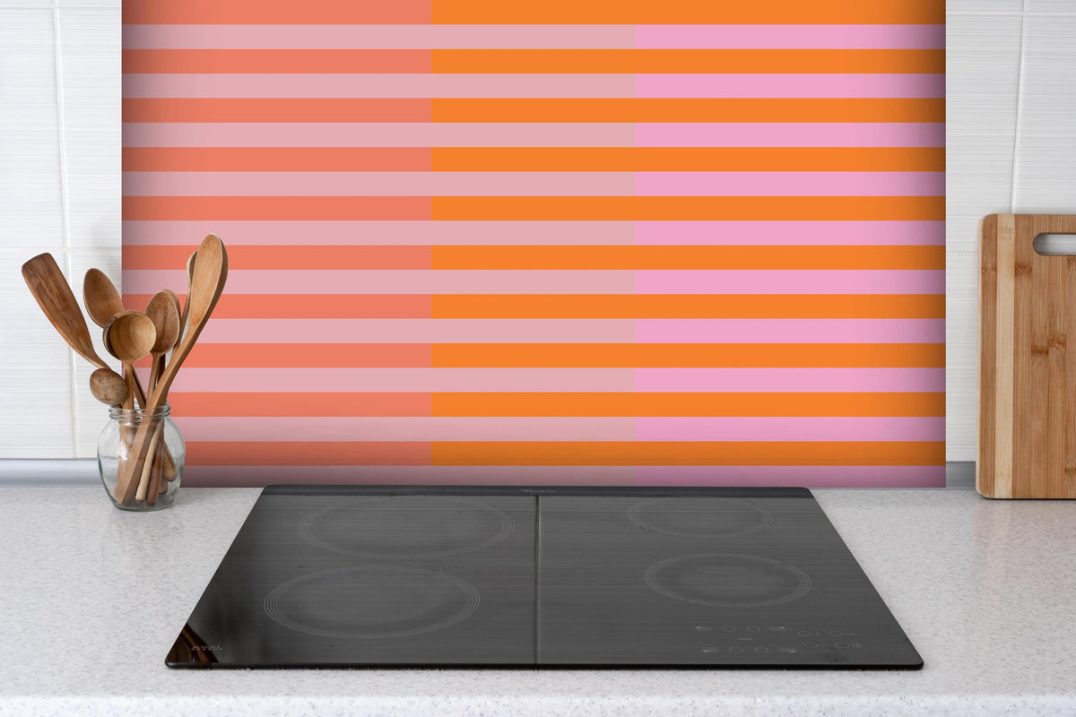 Spritzschutz - The Oranges - Multy Stripes - Coral hinter einem Cerankochfeld zwischen Holz-Kochutensilien