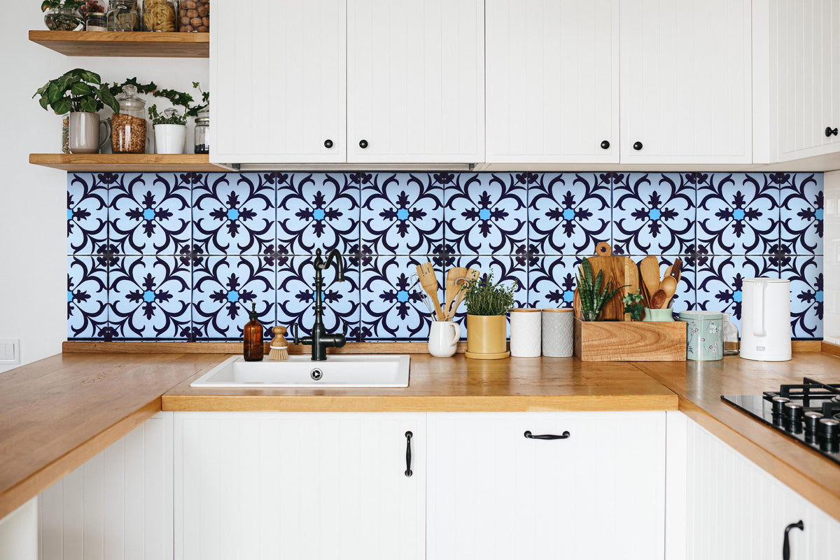 Küche - Bläulich traditionelles Mosaik Motiv in weißer Küche hinter Gewürzen und Kochlöffeln aus Holz