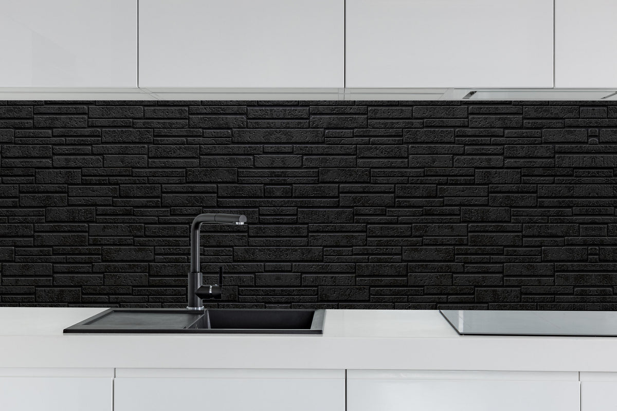 Küche - Panorama - Schwarze Steinmauer hinter weißen Hochglanz-Küchenregalen und schwarzem Wasserhahn
