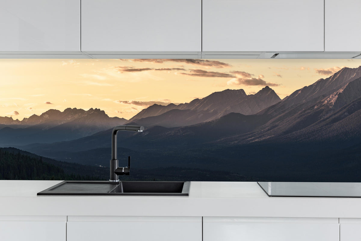Küche - Panorama des Kooteney Valley bei Sonnenuntergang hinter weißen Hochglanz-Küchenregalen und schwarzem Wasserhahn
