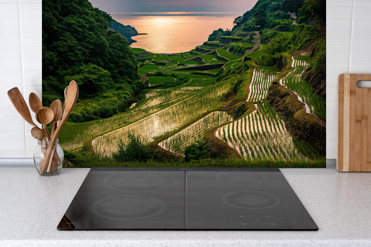 Spritzschutz - Abendlicher Blick japanische Berglandschaft hinter einem Cerankochfeld zwischen Holz-Kochutensilien
