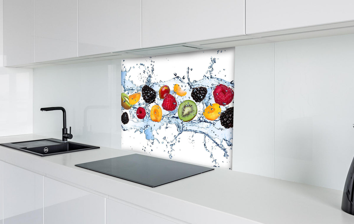 Spritzschutz - Buntes Fruchtwasser-Splash Fotografie hinter einem Cerankochfeld zwischen Holz-Kochutensilien
