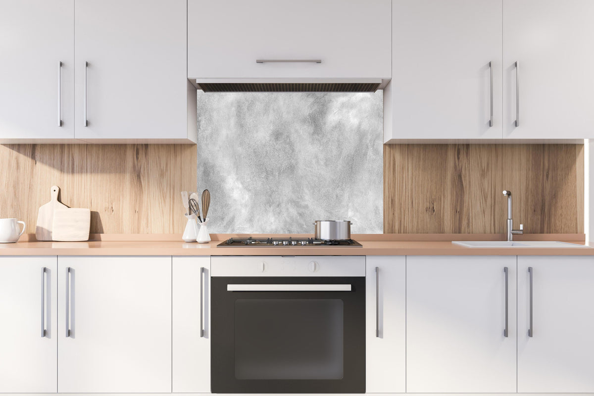 Spritzschutz - Gräuliches Marmor Design hinter einem Cerankochfeld zwischen Holz-Kochutensilien
