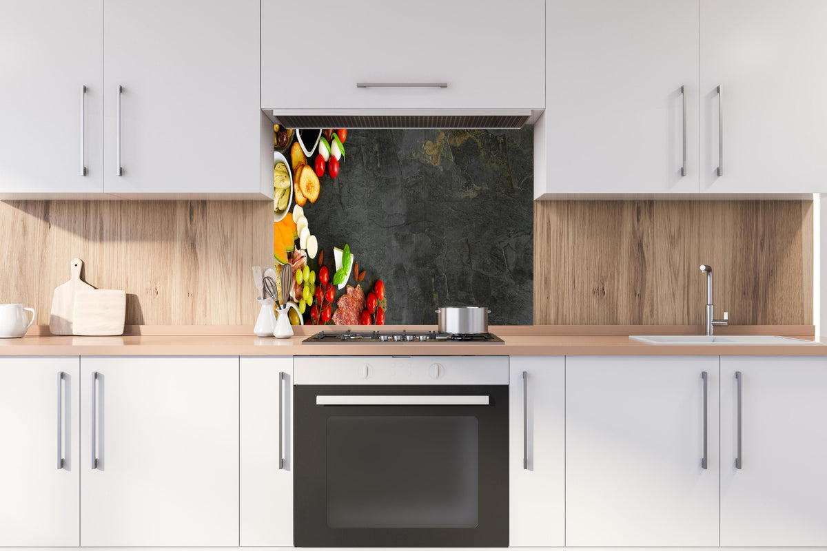 Spritzschutz - Italienisches Schlemmer-Frühstück hinter einem Cerankochfeld zwischen Holz-Kochutensilien
