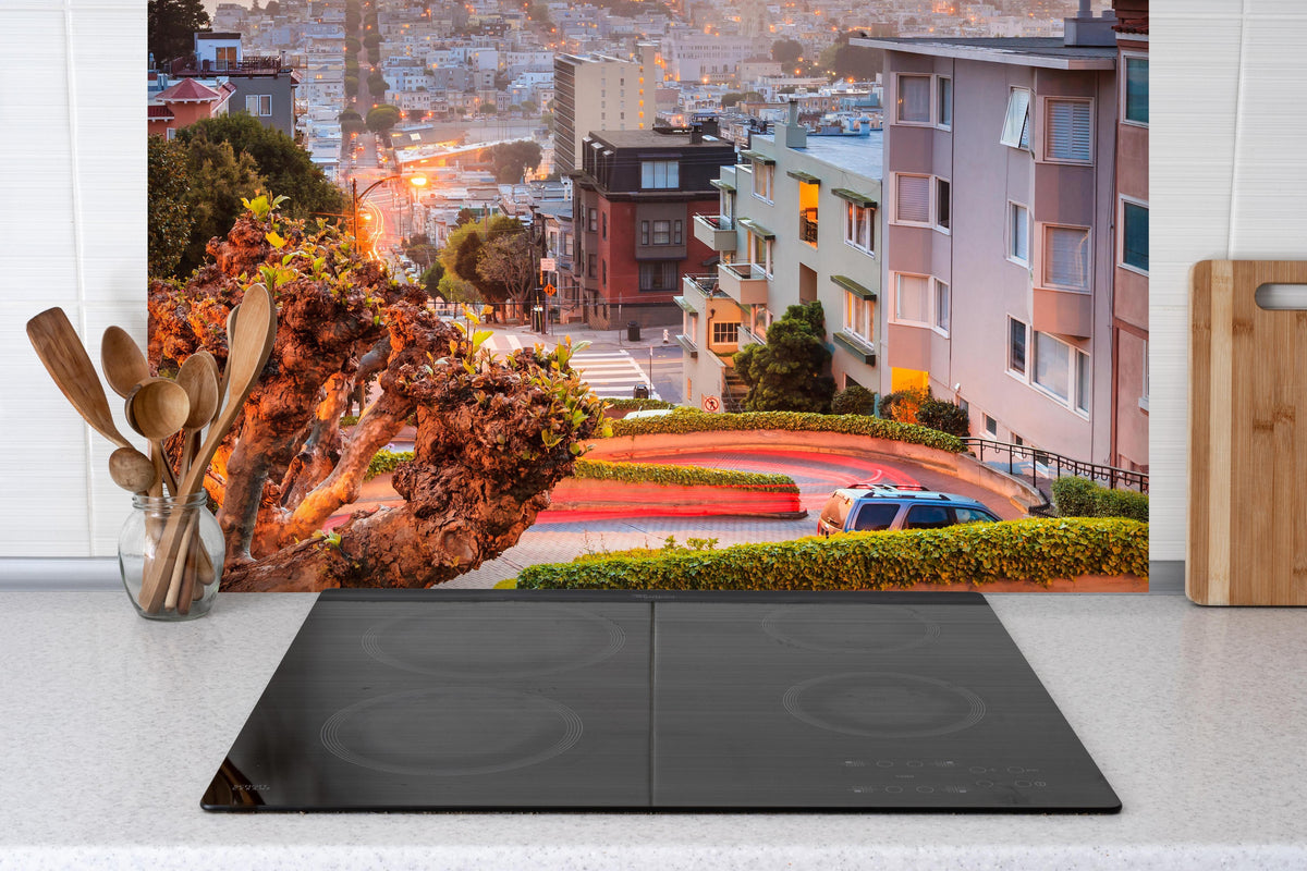 Spritzschutz - Berühmte Lombard Street in San Francisco hinter einem Cerankochfeld zwischen Holz-Kochutensilien
