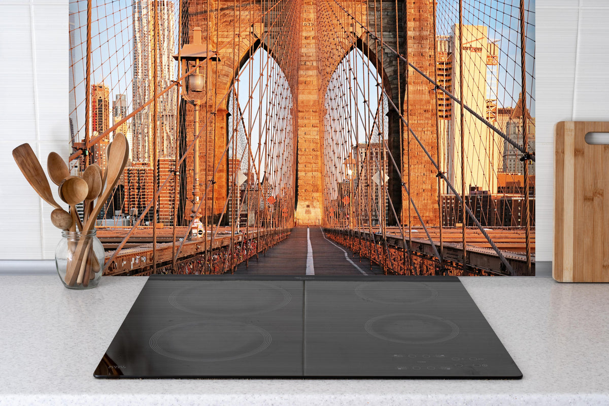 Spritzschutz - Brooklyn Bridge bei Sonnenaufgang hinter einem Cerankochfeld zwischen Holz-Kochutensilien
