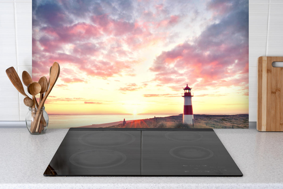 Spritzschutz - Dünen am Leuchtturm - Sylt hinter einem Cerankochfeld zwischen Holz-Kochutensilien
