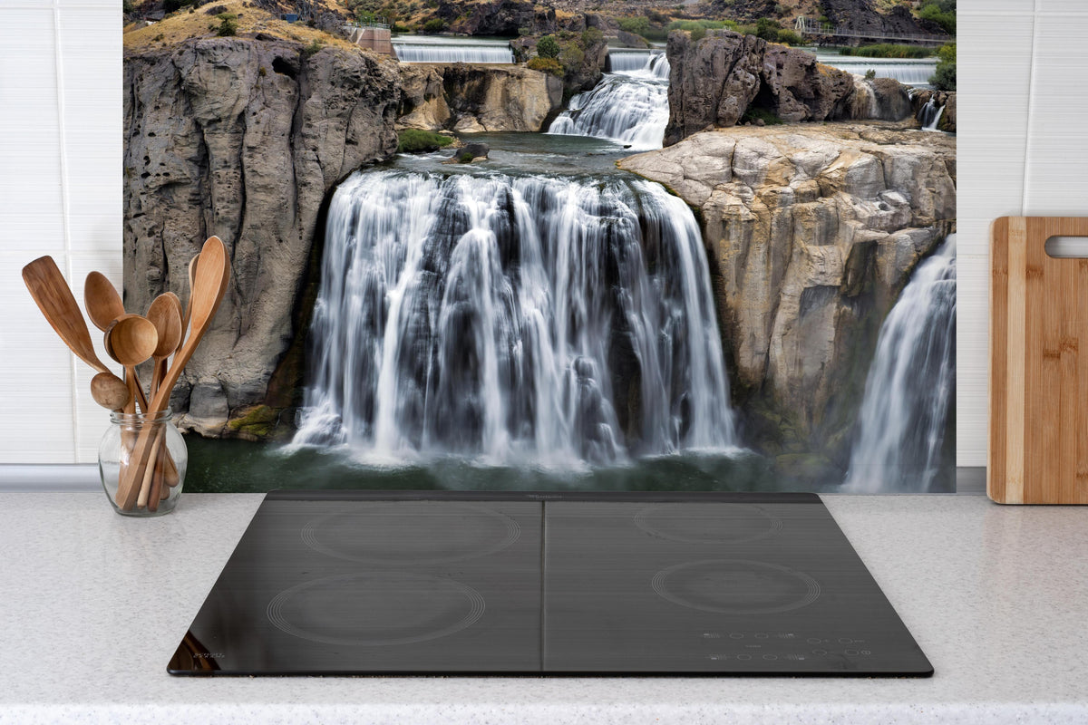 Spritzschutz - Shoshone Wasserfall hinter einem Cerankochfeld zwischen Holz-Kochutensilien
