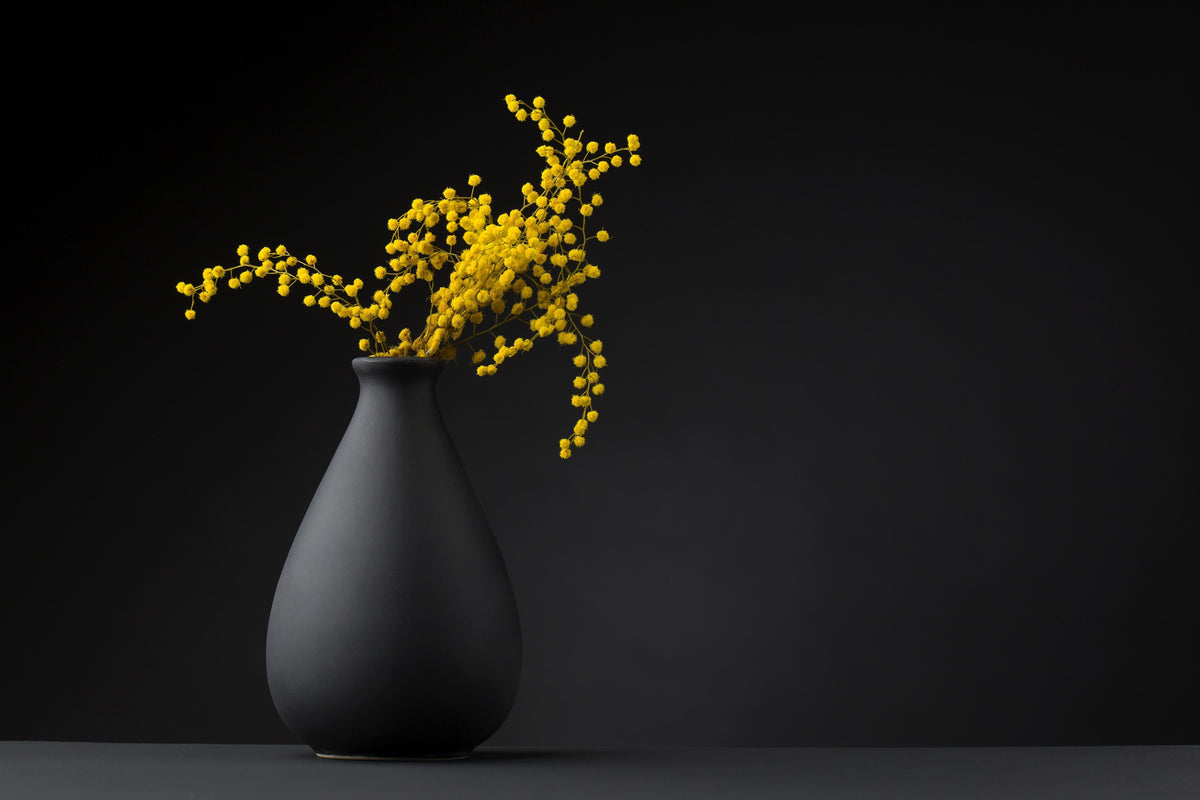 Spritzschutz-gelbe Blume auf der gräulichen Vase