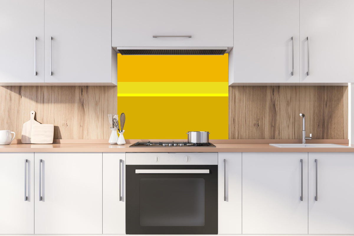 Spritzschutz - The Yellows - Horizontal - Lemon hinter einem Cerankochfeld zwischen Holz-Kochutensilien
