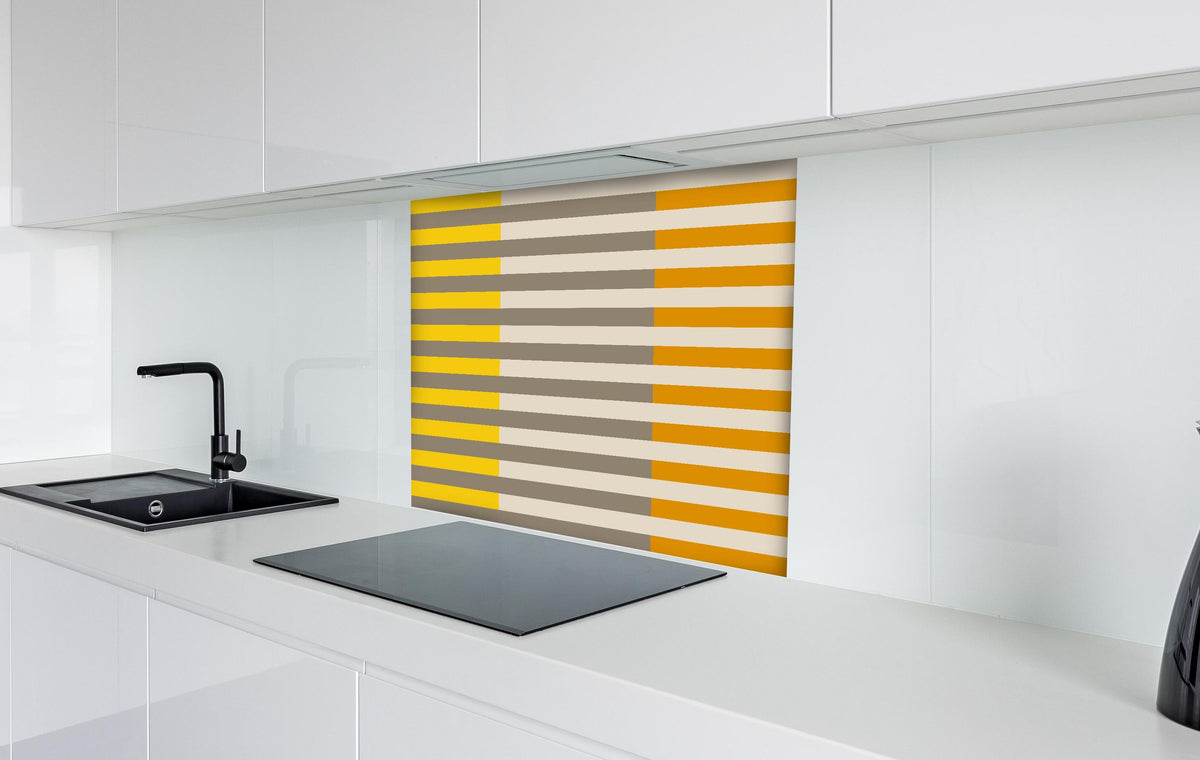 Spritzschutz - The Yellows - Multy Stripes - Saffron hinter einem Cerankochfeld zwischen Holz-Kochutensilien
